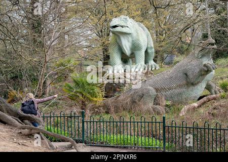 I visitatori possono ammirare le sculture di dinosauri, patrimonio dell'umanità dell'epoca vittoriana di grado i, a Crystal Palace Park, il 3rd aprile 2023, a Londra, in Inghilterra. Crystal Palace Park ha ricevuto £304.000 dal National Lottery Heritage Fund per contribuire al miglioramento e al restauro della sua “isola dei dinosauri”, dove 30 pterodattili, un megalosauro e sculture di iguanodoni sono stati creati solo 10 anni dopo la coniazione del termine “dinosauro”, E sette anni prima che Charles Darwin pubblicasse la sua teoria dell'evoluzione. Foto Stock