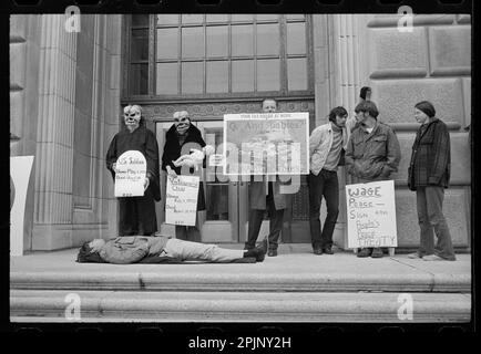 MANIFESTAZIONE ANTI-GUERRA ALL' I.R.S. con il giovane uomo sdraiato a terra e altri che indossano maschere e cartelli che protestano contro il massacro di My Lai in Vietnam, Washington, DC, 4/28/1971. (Foto di Warren K Leffler/US News and World Report Collection) Foto Stock