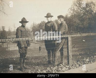 Maschere di garza influenzale indossate da due dei tre soldati che si rilassano nel campo per prevenire la diffusione dell'influenza spagnola, ft. Thomas, KY, 1/28/1919. (Foto di US Army Signal Corps) Foto Stock