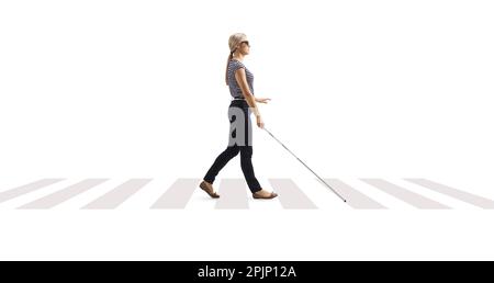 Immagine a tutto profilo di una giovane donna cieca che cammina con una canna bianca in un passaggio pedonale isolato su sfondo bianco Foto Stock