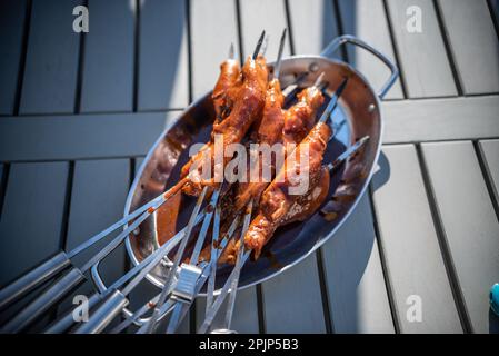 Grigliare gli spiedini con pollo marinato in un recipiente di metallo Foto Stock