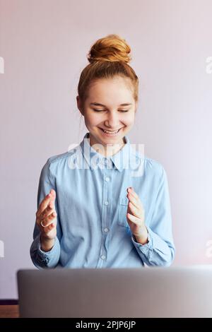 Giovane studentessa che ha classi, imparare online, guardare la lezione da remoto, ascoltare il professore, parlare con i compagni di classe in videochiamata da casa Foto Stock