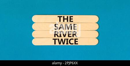 Lo stesso fiume due volte simbolo. Concetto parole lo stesso fiume due volte su bastone di legno. Bellissimo sfondo blu tavolo. Business motivazionale lo stesso Foto Stock