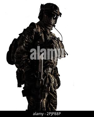 Tiro a basso angolo di un soldato militare in mimetizzazione con fucile d'assalto. Scatto da studio, contrasto scuro, ritagliato, desaturato, isolato su sfondo bianco Foto Stock