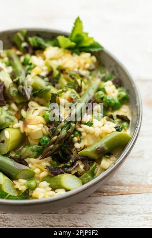 Risotto primaverile con asparagi, piselli, limone e menta Foto Stock