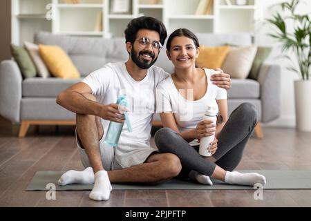 Coppia indiana sportiva che si allenano insieme a casa e si posano alla macchina fotografica Foto Stock