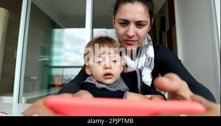 Genitori e figli che usano il cellulare. Madre e bambino che tengono lo smartphone Foto Stock