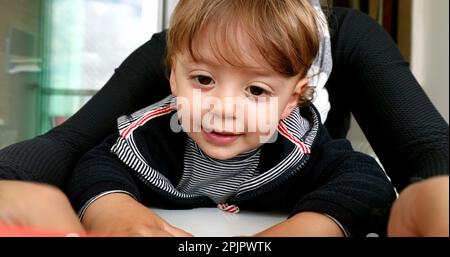 Bambino in giro per la madre, genitore che tiene il cellulare multi-tasking Foto Stock