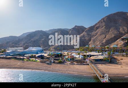 Eilat, israele - 25 novembre 2022: Vista aerea del parco marino osservatorio di Eilat con ponte sul mare ondoso circondato da montagne rocciose Foto Stock