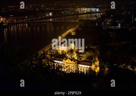 Vista notturna ad angolo alto lungo il Danubio verso Piazza San Gellért dalla collina di Gellert, Budapest, Ungheria. Foto Stock