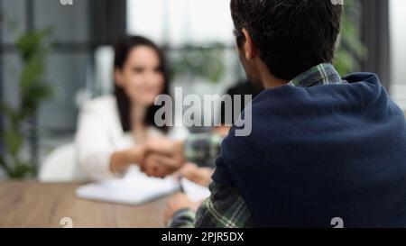 Si siede al tavolo con i computer portatili. Giovani uomini d'affari in abiti formali che lavorano in ufficio Foto Stock