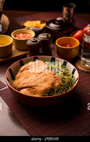 Pasta verde con pollo fritto cibo peruviano tavola a buffet assortiti piatti gourmet cucina Perù tradizionale Foto Stock