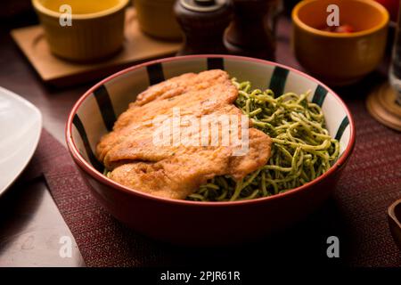 Pasta verde con pollo fritto cibo peruviano tavola a buffet assortiti piatti gourmet cucina Perù tradizionale Foto Stock