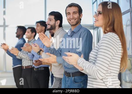 Un team di lavoro felice applaudendo dopo una riunione di successo Foto Stock