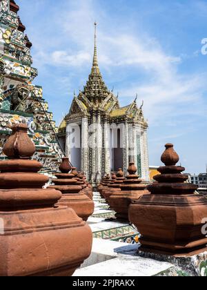 Al Tempio di Wat Arun, il Tempio di Dawn, un edificio spicca con il suo magnifico tetto dorato e la guglia. Le piramidi di terracotta che la circondano Foto Stock