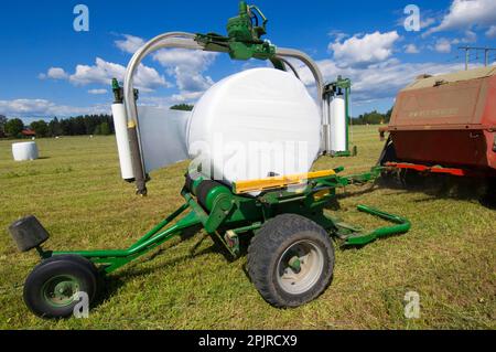 Rotopresse insilate in plastica, avvolte con avvolgitore meccanico, Svezia Foto Stock