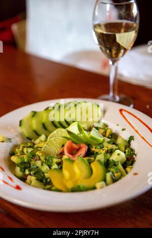 Insalata di avocado servita con vino bianco Foto Stock