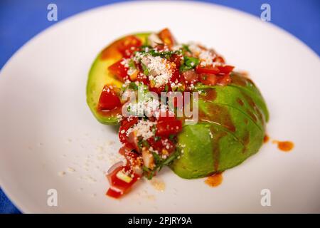 Insalata di avocado con formaggio e salsa calda Foto Stock
