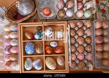 PRODUZIONE - 21 marzo 2023, Brandeburgo, Rüdersdorf: Diverse uova di Pasqua raccolte e disegnate da sola giacciono in scatole di Renate Radoy. Nonostante la sua età avanzata, l'artigiano di 91 anni ha una mano incredibilmente stabile: Incisa modelli, motivi o poesie in gusci d'uovo. Quando non è il periodo pasquale, il nativo di Berlino è attivo a molti livelli per il suo paese adottato. (A dpa 'fragile decorazione di Pasqua - 91 anni fa opere d'arte fuori dalle uova') Foto: Patrick Pleul/dpa Foto Stock