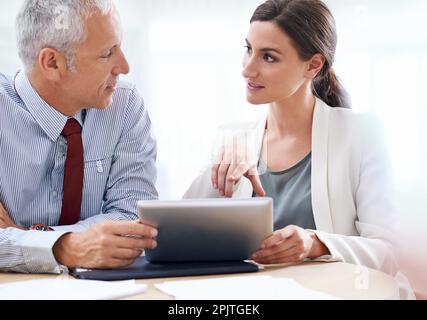 Tecnologia a supporto dei processi aziendali. due colleghi che utilizzano un tablet digitale al lavoro. Foto Stock