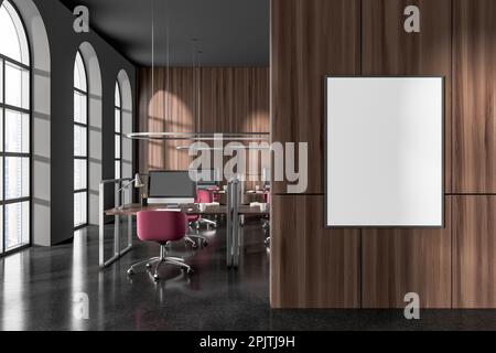 Interno di moderno ufficio open space con pareti grigie e in legno, pavimento in pietra, file di tavoli per computer con sedie rosa e poster verticale a forma di mock up fra Foto Stock