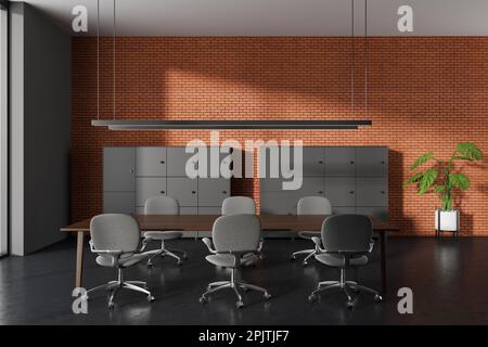 Muro di mattoni interni ufficio con tavolo da riunione, poltrone e ripiani su pavimento in cemento nero. Zona conferenze con arredi moderni e design minimalista Foto Stock