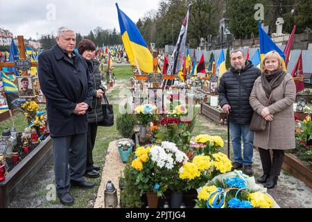 1 aprile 2023, Lviv, Ucraina: La gente sta vicino alla tomba di un soldato caduto ad una cerimonia commemorativa in un cimitero a Lviv. Yurii Ruf era uno scrittore di Leopoli, figura pubblica, patriota dell'Ucraina e una persona ben nota a Leopoli e in Ucraina. Ha organizzato molti eventi, un festival, ecc. Quando iniziò la guerra, andò in prima linea come volontario e fu ucciso durante una missione di combattimento nella regione di Luhansk il 1 aprile 2022. L'evento nelle foto è la commemorazione di Yuriy nella chiesa e sul campo delle onorate sepolture nel cimitero di Lychakivskyi a Lviv nel primo anniversario della sua morte. Parenti, f Foto Stock