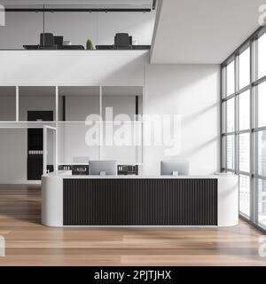 Interno bianco della sala ufficio con banco ricevimento e computer. Business hall a due piani con zona coworking e arredamento moderno. Finestra panoramica o Foto Stock