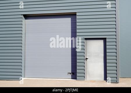 serrande in metallo grigio su lamiera profilata verticale nuovo edificio industriale grigio Foto Stock