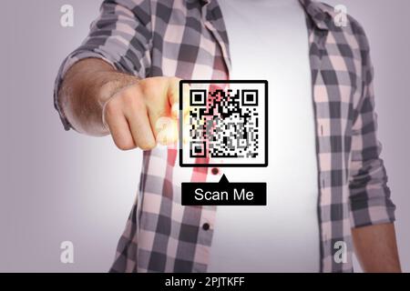 Uomo che indica l'illustrazione del codice QR su sfondo grigio chiaro, primo piano Foto Stock