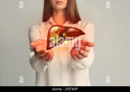 Donna e illustrazione di fegato malsano su sfondo grigio chiaro. Epatite virale Foto Stock