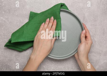 Piastra per pulizia donna su tavolo grigio chiaro, vista dall'alto Foto Stock