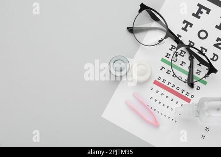 Composizione con lenti a contatto su sfondo grigio chiaro, vista dall'alto. Spazio per il testo Foto Stock