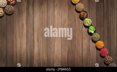 imposta condimenti colorati su un tavolo di legno. Sfondo di spezie ed erbe per etichette di alimenti Foto Stock