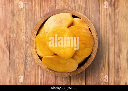 frutta secca, metà pesca in ciotola di legno sullo sfondo della tavola. cibo vegetale sano. Foto Stock