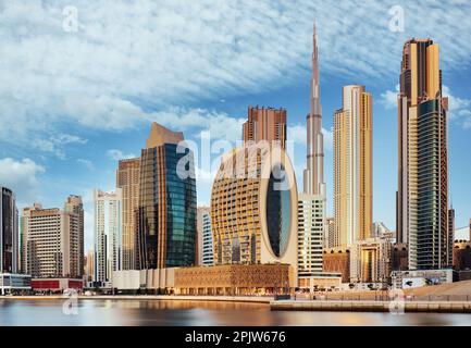 Panorama dello skyline del centro di Dubai con riflessi nel Dubai Creek all'alba, dal lungomare del porto di Dubai Creek. UAR Foto Stock