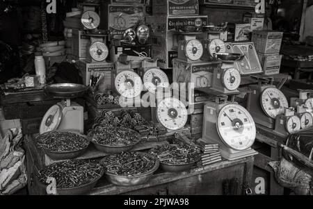 Bilance, chiodi, cerniere e altri ferramenta e ferramenta in vendita su uno stand del mercato centrale di PLEIKU, Vietnam. Foto Stock