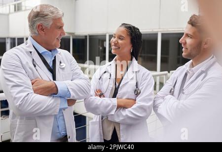 Discussione, assistenza sanitaria e team di medici in ospedale parlare in corridoio dopo la consultazione. Collaborazione, lavoro di squadra e gruppo di professionisti Foto Stock