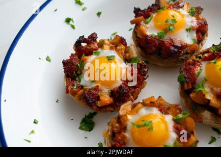 Funghi al forno ripieni di sobrasada e quaglia d'uovo. Tradizionale tapa spagnola. Foto Stock