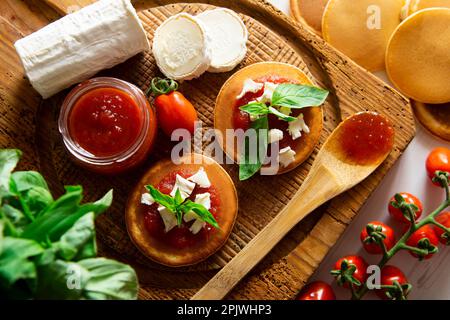 Frittelle con formaggio di capra e marmellata di pomodoro. Foto Stock