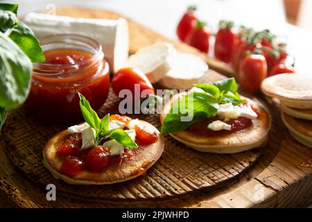 Frittelle con formaggio di capra e marmellata di pomodoro. Foto Stock