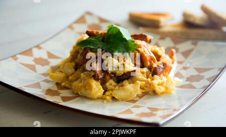 Strapazzate con uova e funghi sul pane tostato. Foto Stock