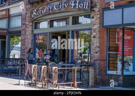 Knoxville, Tennessee, USA - 25 marzo 2023: Le persone si trovano fuori da un bar nel centro città. Foto Stock