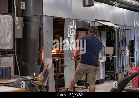 Knoxville, Tennessee, USA - 25 marzo 2023: Un uomo lavora al soffiaggio del vetro nel centro storico di Knoxville. Foto Stock