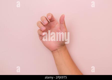 Primo piano della mano maschile che raggiunge pronto per aiutare o ricevere isolato su sfondo rosa. Aiutare la mano tesa per la salvezza. Foto Stock