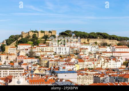 Vista da Miradouro de Sao Pedro de Alcantara del quartiere Baixa con Castelo Sao Jorge (Castello di San Giorgio) in lontananza, Lisbona, Portogallo. Foto Stock