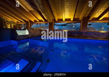 La piscina riscaldata di fronte alla neve dell'hotel Sant'Orso nel comune di Cogne, ai piedi del gruppo Gran Paradiso. Valle d'Aosta, Italia, Euro Foto Stock