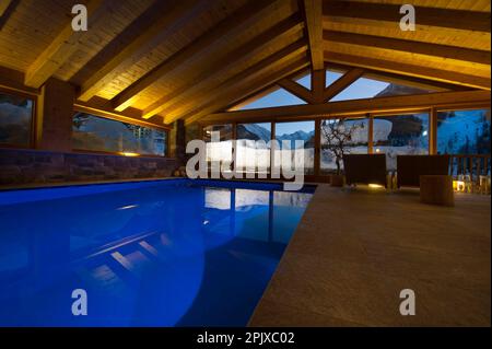 La piscina riscaldata di fronte alla neve dell'hotel Sant'Orso nel comune di Cogne, ai piedi del gruppo Gran Paradiso. Valle d'Aosta, Italia, Euro Foto Stock