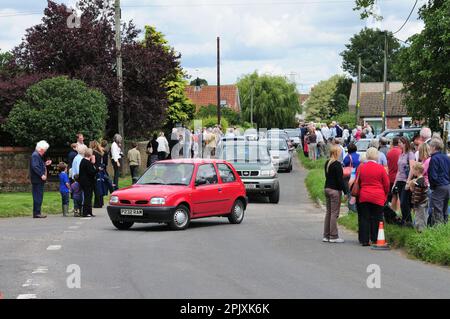 Folle e congestione del traffico nel villaggio di Poulshot, nel Wiltshire, in attesa dell'arrivo dei cavalli Wadworth shire nel 2009. Foto Stock