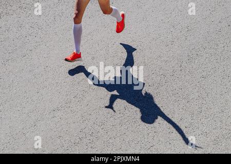 gambe donna runner in compressione calzini corsa, positivo silhouette donna atleta jogger in strada Foto Stock